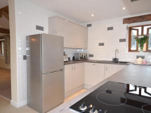 una cocina con nevera de acero inoxidable y armarios blancos en 4 Bed in Berrynarbor 43640, en Berrynarbor 8 fotos más