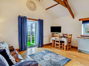 Una sala de estar con una mesa y un reloj en la pared. en 1 Bed in Hartland LINNE, en Hartland