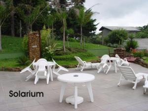 a group of white chairs and tables on a patio at Gramado Village Apartamento no Centro in Gramado