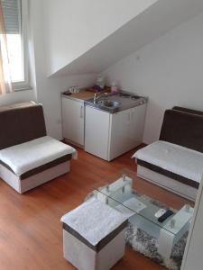 mały salon z umywalką i stołem w obiekcie Apartmani i sobe Milojević w mieście Trebinje