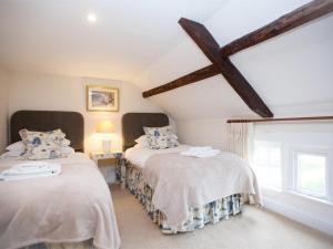 Dos camas en una habitación con ventana. en 2 Bed in Osmotherley G0172, en Osmotherley