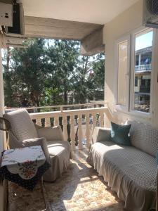 einen Balkon mit Stühlen, einem Tisch und einem Fenster in der Unterkunft Apartments with sea view in Kobuleti