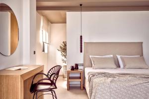 a bedroom with a bed and a desk and chairs at Villa Julieta 2 by Villa Plus in Tragaki
