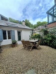 Un patio con una mesa y sillas frente a una casa. en Le Cinquante-Trois, en Saint-Valéry-en-Caux