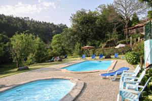 a swimming pool with lounge chairs and a resort at Quinta da Chanca in Paredes de Coura