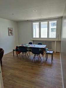 a room with a table and chairs in it at T4 coeur de ville, à deux pas de la plage - 3 chambres in Saint-Nazaire