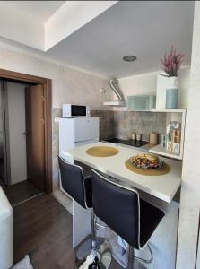 a kitchen with a counter with chairs and a table at Petrovac in Petrovac na Moru