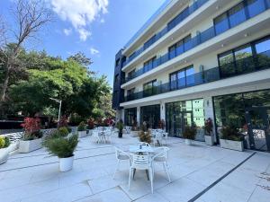 a patio with tables and chairs in front of a building at Hotel Eforie Nord in Eforie Nord
