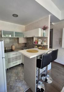 a kitchen with a counter and two bar stools at Petrovac in Petrovac na Moru +9 photos