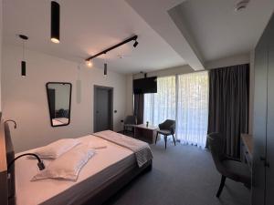 a bedroom with a bed and a desk and a mirror at Hotel Eforie Nord in Eforie Nord +61 photos