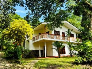 a house with a balcony in the yard at Marisol Villa in Unawatuna
