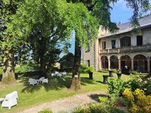 a building with a yard with white tables and trees at Château de Fortis in Serrières-en-Chautagne