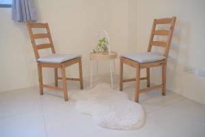 a room with three chairs and a rug on the floor at Yuejin Port B&B in T'u-k'u