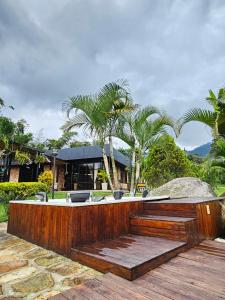 a house with a wooden fence and palm trees at Casa Bonita Namay in Albán