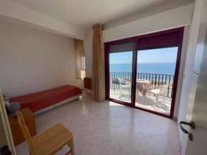 a bedroom with a bed and a view of the ocean at Hotel Lungomare Brancaleone in Brancaleone Marina