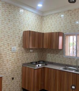 a kitchen with wooden cabinets and a stove in it at Jackson's Court and Apartment in Abuja