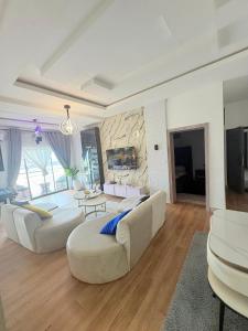 a living room with two white couches and a stone wall at 2bedroom luxury apartment in Lekki