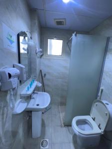 a bathroom with a sink and a toilet at AL-Diyafh Hotel in Az Zāhir