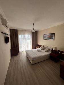 a bedroom with a white bed and a large window at Albayrak Hotel in Çeşme +19 photos