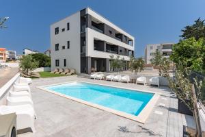 a villa with a swimming pool in front of a building at Villa SHARK 2 with a pool in Novalja