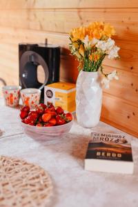 a table with a vase of flowers and a bowl of strawberries at Polna Przystań 694-272-463 in Uherce Mineralne (7) +18 photos