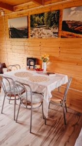 a dining room with a table and four chairs at Polna Przystań 694-272-463 in Uherce Mineralne (7)