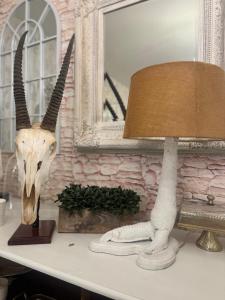 a skull of a antelope and a lamp on a table at J and M on Capital Boutique Guesthouse in Frankfort