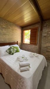 una camera da letto con un letto grande con asciugamani sopra di Vila das Mangabeiras Corumbau a Corumbau