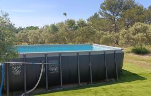 a large swimming pool with a hose around it at La Cayon Au coeur des oliviers en Provence in Pélissanne
