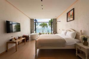 大理古镇Dali Blue House Sea View B&B的一间带大床和浴缸的卧室