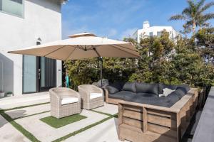 マンハッタン・ビーチにあるYour Coastal Getaway in Manhattan Beach Awaitsのパティオ(ソファ、パラソル付)