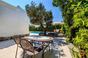 a patio with a table and chairs next to a pool at Ca Rulleta Jávea in Jávea