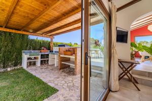 a patio with a sliding glass door to a patio with a television at Ca Rulleta Jávea in Jávea