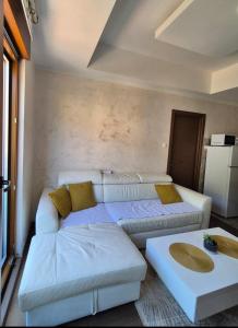 a living room with a white couch and a table at Petrovac in Petrovac na Moru