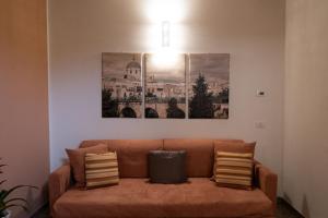 a couch in a living room with three pictures on the wall at BONA NOVA-Puglia Living in Massafra +24 photos