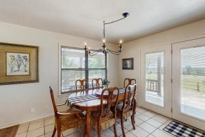 Un comedor con mesa y sillas y ventanas. en Casa Austin, en Fredericksburg