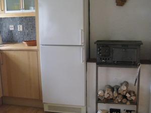 a white refrigerator in a kitchen with a stove at Stuga i skogsbryn in Olofström