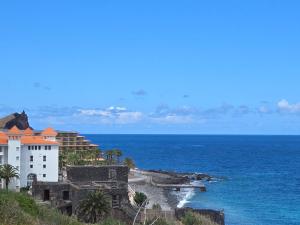 a building on a hill next to the ocean at Grayscale Studio in Caniço