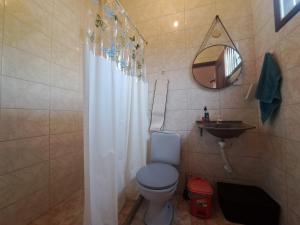 a bathroom with a white shower curtain and a toilet at Casa ampla Churrasqueira Natureza Maricá RJ in Maricá +15 photos