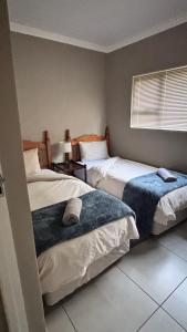 Un dormitorio con dos camas y una ventana. en Searle Cottage, en George