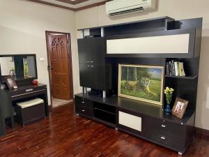 a living room with a black entertainment center at Yoga Bed and Breakfast in Chiang Mai