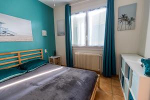 Un dormitorio con una cama con paredes azules y una ventana. en Gite west landes, en Onesse-et-Laharie 30 fotos más