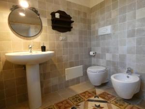 łazienka z umywalką, toaletą i lustrem w obiekcie Villa Miccoli apartments w mieście Ceglie Messapica