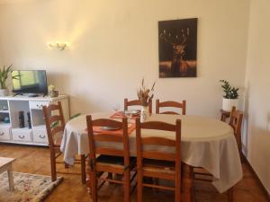 una sala da pranzo con tavolo e un dipinto di cervo sul muro di Zinha's Guest House a Moledo Altre 7 foto