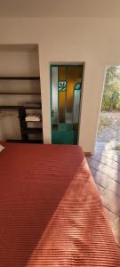 1 dormitorio con 1 cama y una puerta con vidrieras en El Churqui, en Cafayate