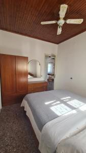 ein Schlafzimmer mit einem Bett und einem Deckenventilator in der Unterkunft Seaside House in Paralia Dionisiou
