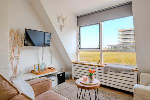 a living room with a couch and a tv at Perfect Stay Holiday, Sea View in Egmond aan Zee