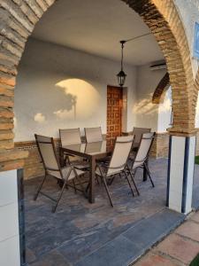a patio with a table and chairs under an archway at Al Alba in Matalascañas
