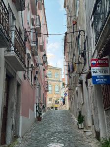 an empty alley with buildings and a street sign at Suite - Centro histórico Mouraria in Lisbon +12 photos