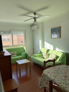 a living room with two green couches and a table at Apartamentos La Almadraba 1-5 in El Pozo del Cabo